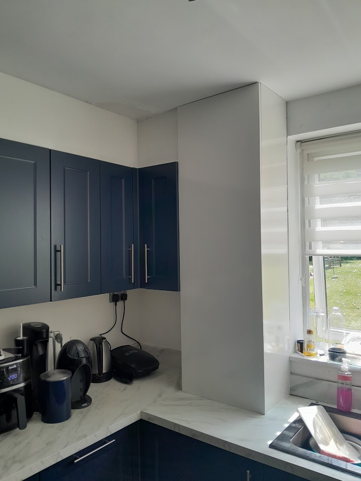 Boxed-in cupboard joinery above navy kitchen units by MyDeskin Carpentry, Keynsham