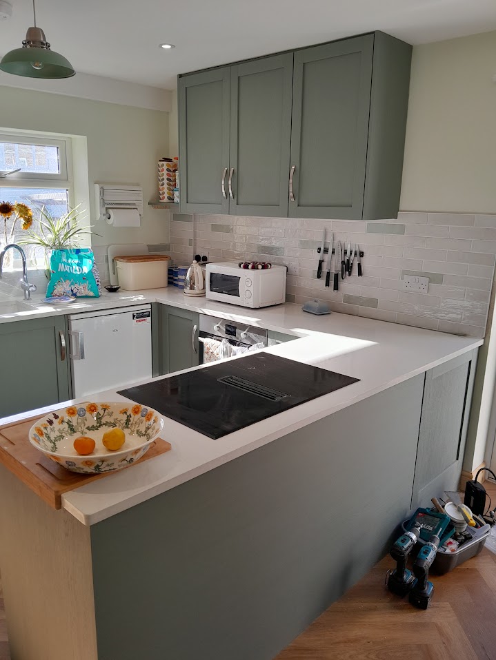 Sage green bespoke kitchen cabinets with white worktops by MyDeskin Carpentry, Keynsham